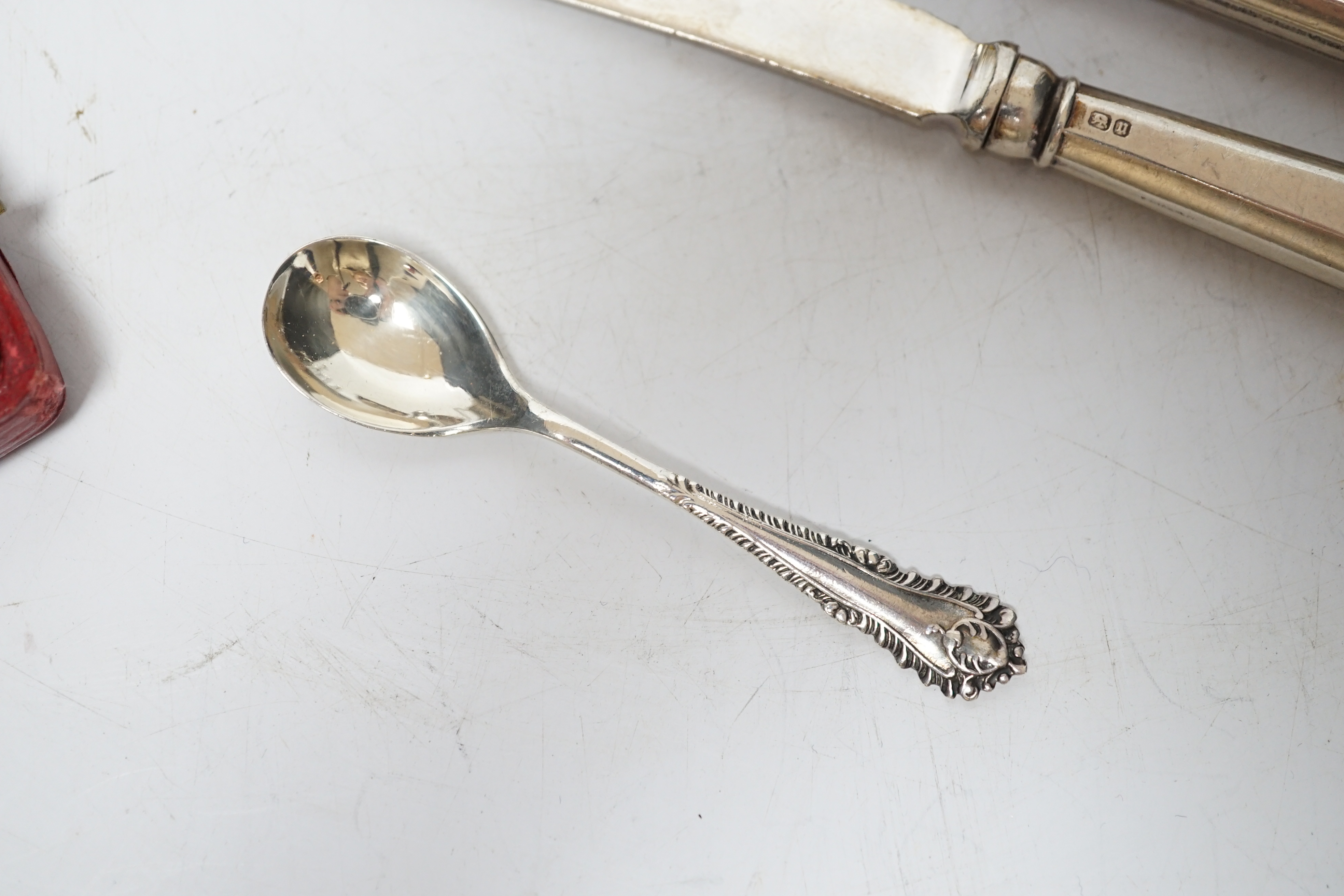 Twelve assorted silver condiments, including a set of four Edwardian bun salts, William Hutton & Sons, London, 1903, a set of six silver handled tea knives, a small silver trophy cup, silver napkin ring, cased silver thi